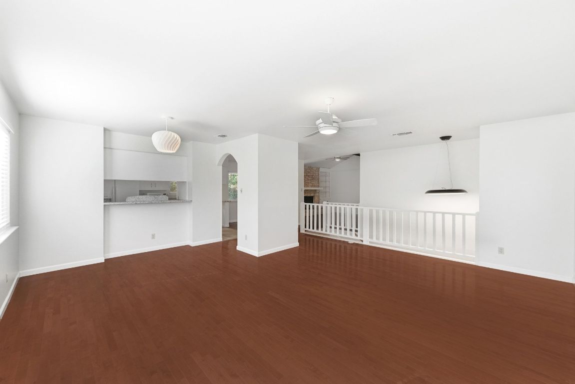 6210 Shadow Valley Drive, Unit A Austin, TX 78731 - Photo 15 of 29 Larger living room featuring arched walkways, dark wood-style floors, a ceiling fan, and healthy amount of natural light
