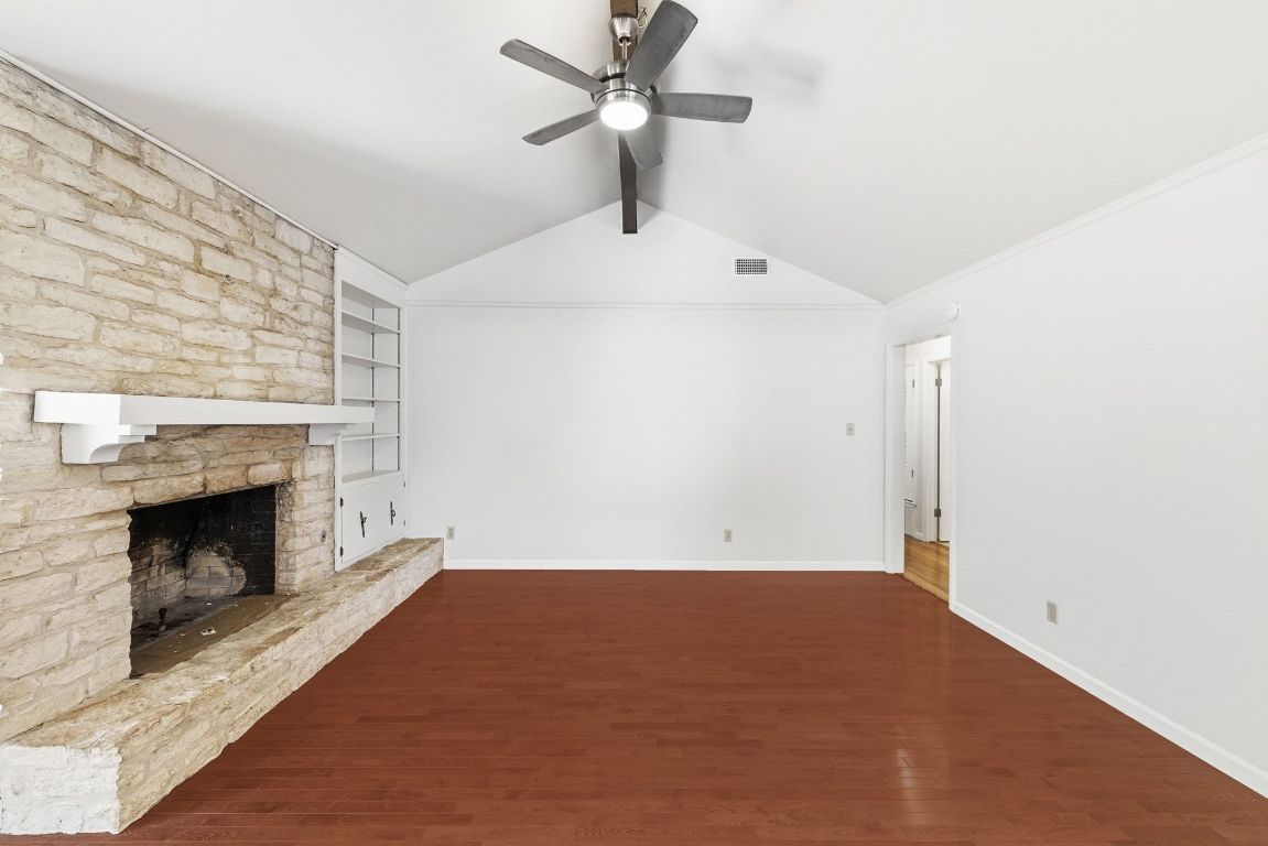 6210 Shadow Valley Drive, Unit A Austin, TX 78731 - Photo 6 of 29 One of two living rooms featuring built in shelves, dark wood finished floors, a fireplace, and ceiling fan