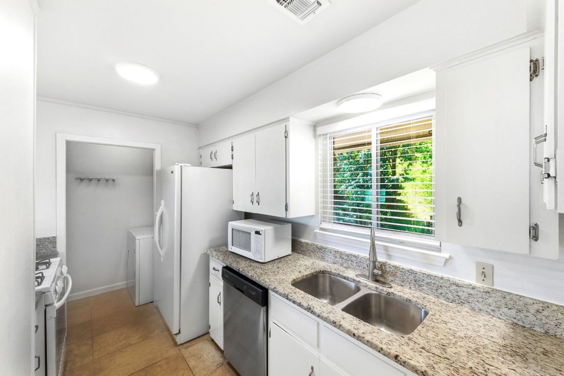 6210 Shadow Valley Drive, Unit A Austin, TX 78731 - Photo 10 of 29 Kitchen featuring white appliances, white cabinetry, light stone countertops, washer / dryer, and light tile patterned flooring