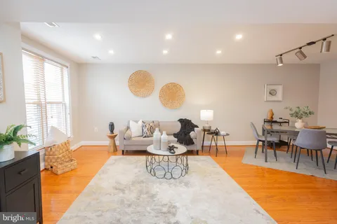 a living room with furniture dining table and a large window