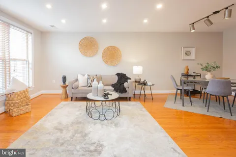 a living room with furniture a rug and a floor to ceiling window