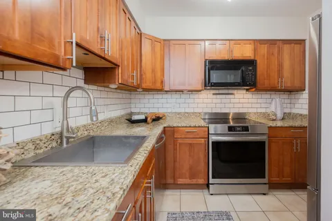 a kitchen with stainless steel appliances granite countertop a sink stove and microwave
