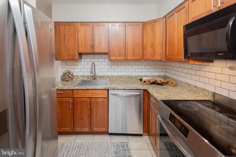 a kitchen with stainless steel appliances granite countertop a stove microwave and refrigerator