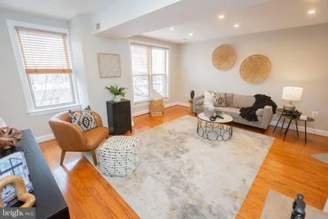 a living room with furniture wooden floor and a large window
