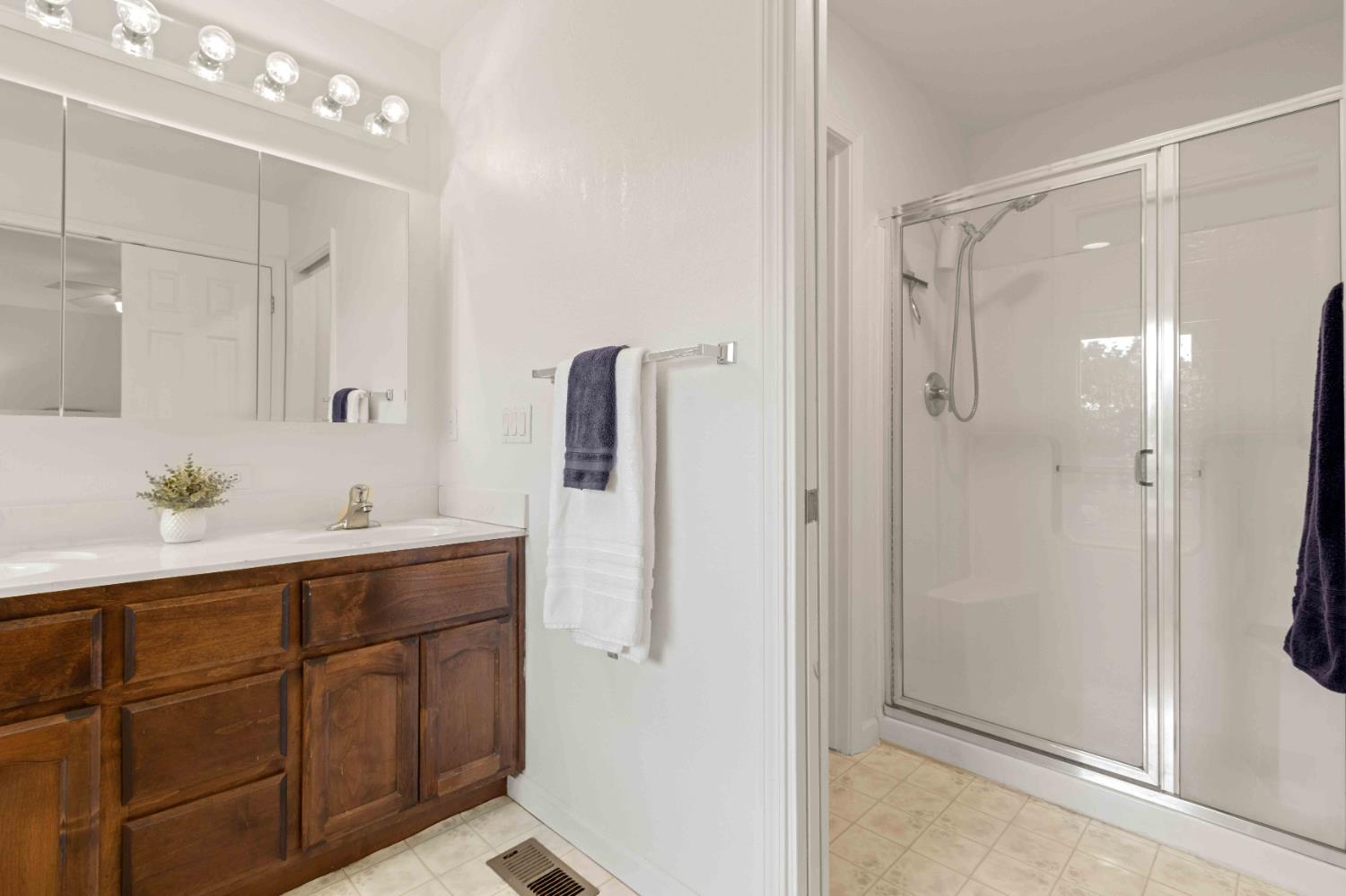 5341 Puerta Del Sol Road Camino, CA 95709 - Photo 18 of 32 a bathroom with a shower sink vanity and mirror