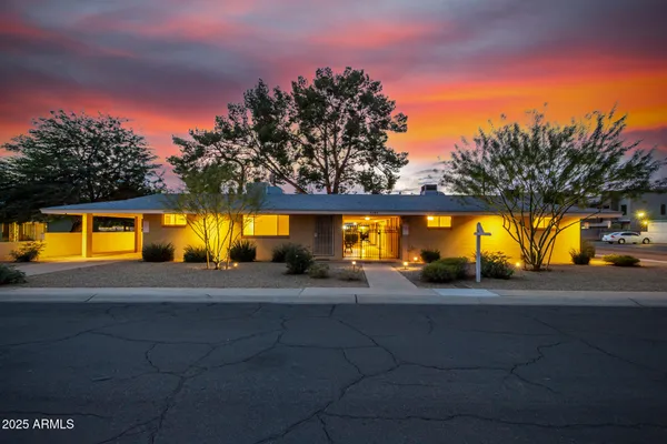 a view of a house with a yard and a car park