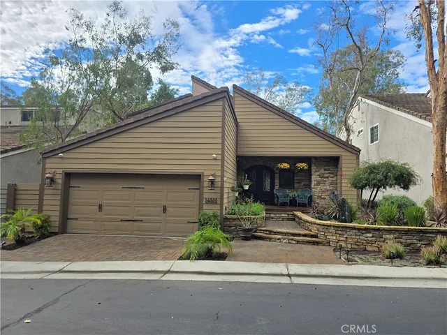 a front view of a house with garage and plants