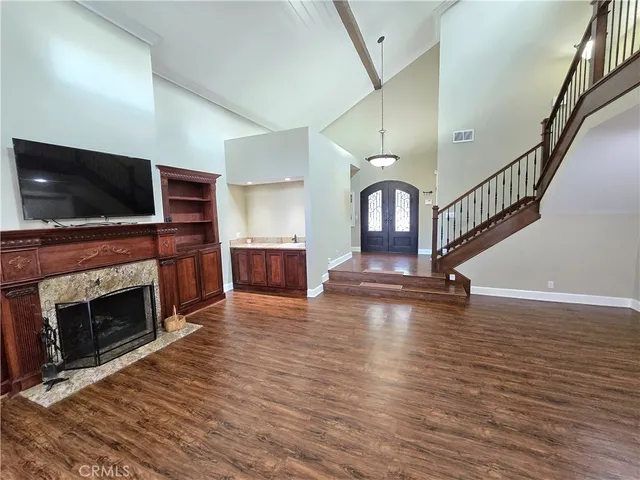 a view of a livingroom with a fireplace wooden floor and staircase