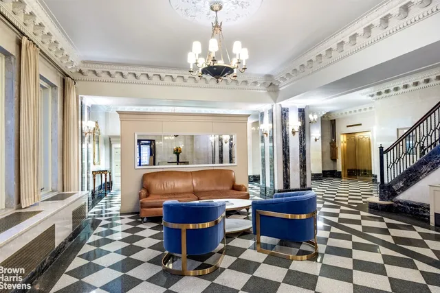 a living room with a furniture a rug and a chandelier