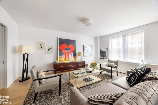 a living room with furniture a rug and a window