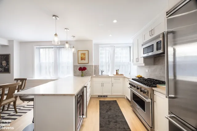 a kitchen with stainless steel appliances a sink stove and cabinets