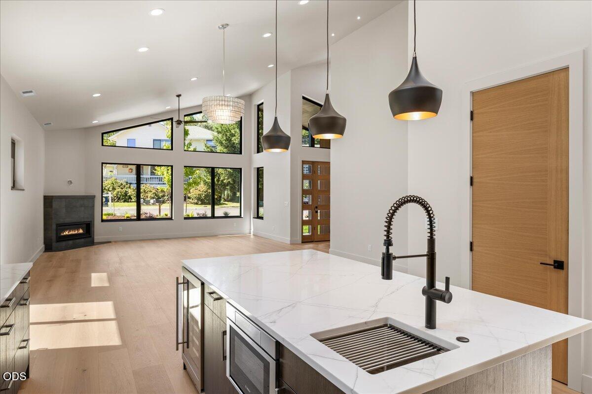 391 Clinton Street Ashland, OR 97520 - Photo 19 of 41 a kitchen with stainless steel appliances a large window a sink a counter space and wooden floor