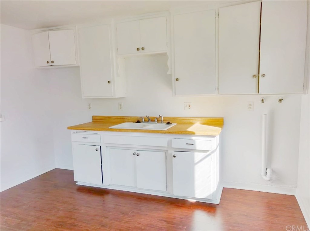 7793 15th Street Westminster, CA 92683 - Photo 4 of 11 a room with a sink cabinets and wooden floor