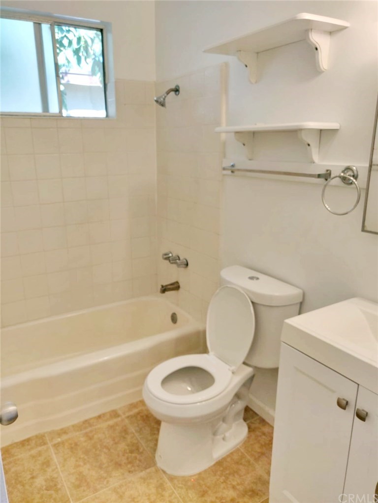 7793 15th Street Westminster, CA 92683 - Photo 8 of 11 a white toilet and tub sitting next to a bathroom sink