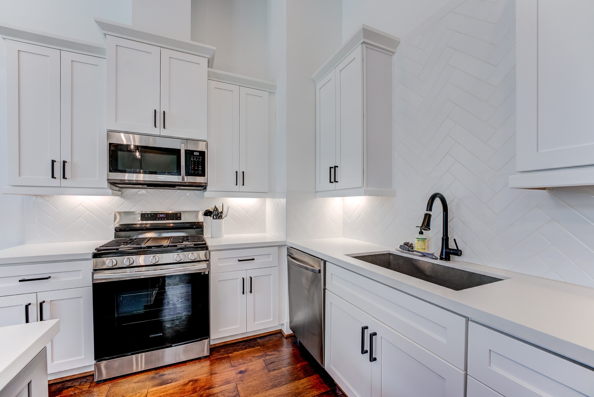 107 West Whitney Street, Unit E Houston, TX 77018 - Photo 26 of 48 a kitchen with white cabinets and stainless steel appliances