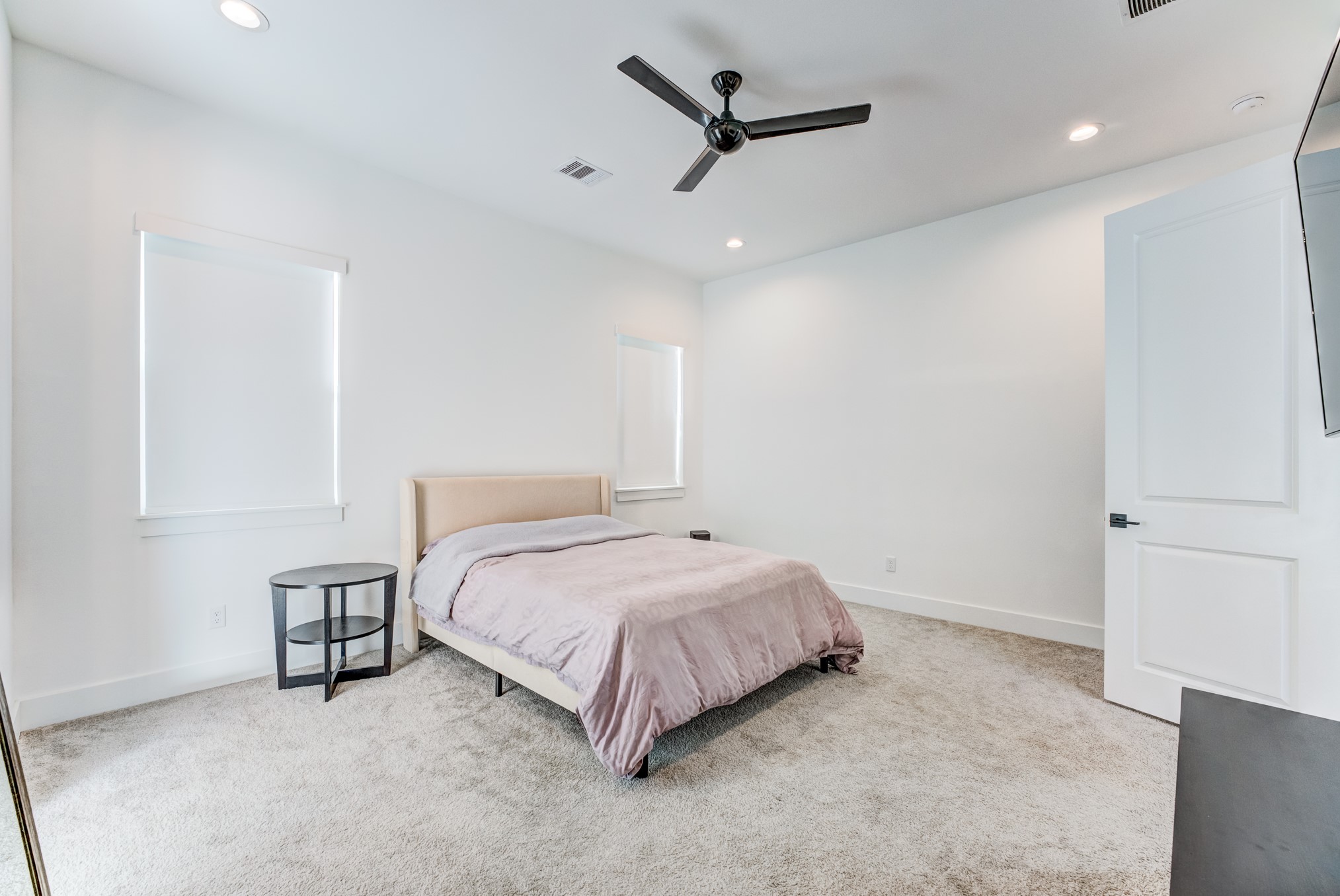 107 West Whitney Street, Unit E Houston, TX 77018 - Photo 31 of 48 a spacious bedroom with a bed and a ceiling fan