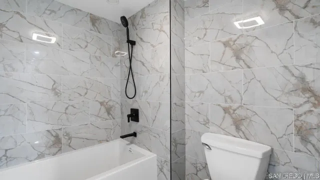 a bathroom with a toilet and shower