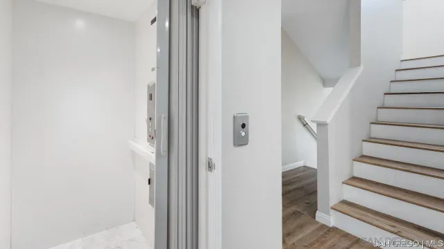 a view of a hallway with wooden floor and entryway
