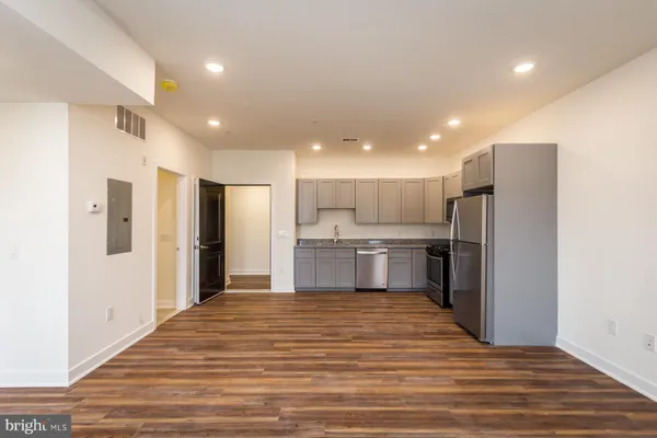 a open kitchen with stainless steel appliances granite countertop a refrigerator and a sink