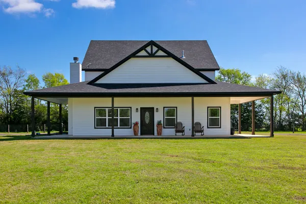 a view of a house with large windows and a big yard