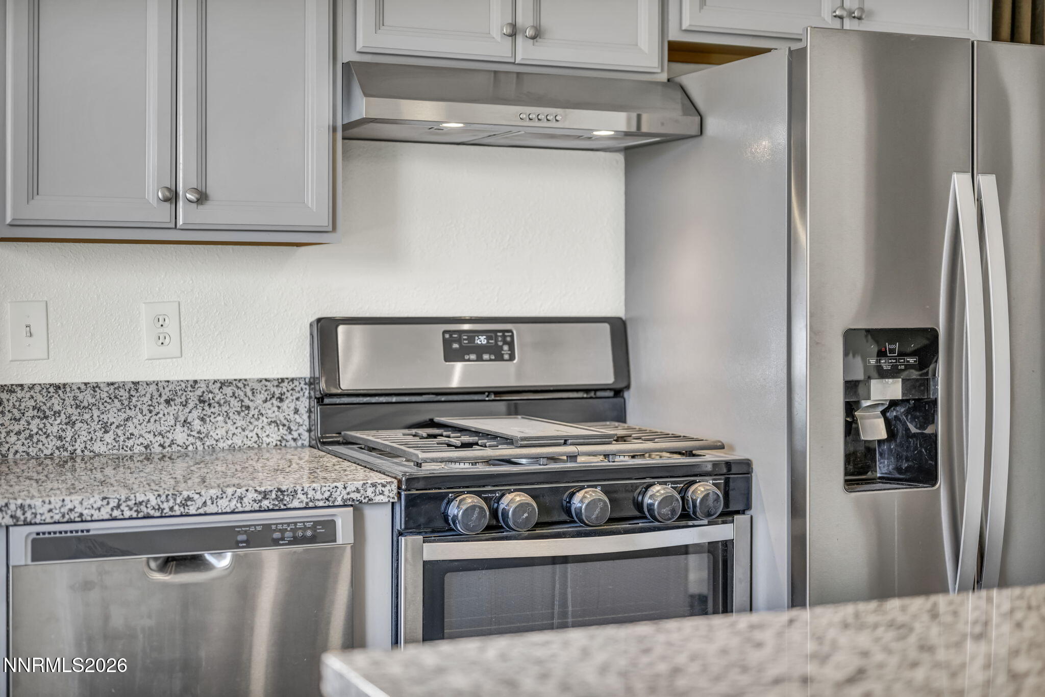 7575 Halifax Drive Reno, NV 89506 - Photo 18 of 58 a kitchen with stainless steel appliances granite countertop a stove and a refrigerator with white cabinets