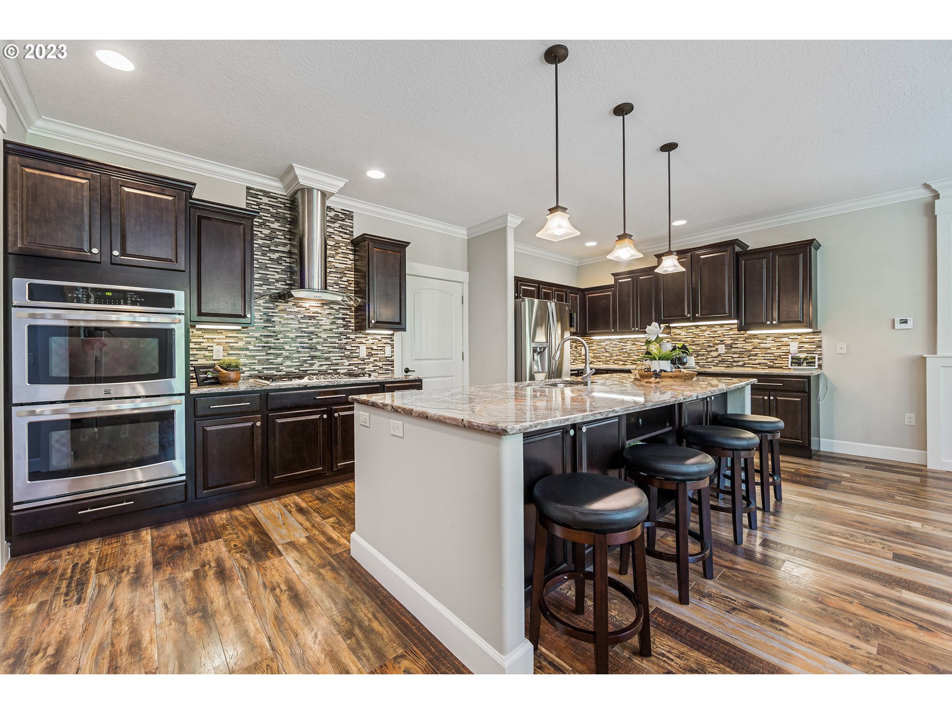 5316 Southwest Childs Road Lake Oswego, OR 97035 - Photo 12 of 42 a kitchen with stainless steel appliances kitchen island granite countertop a stove a sink and a wooden floors