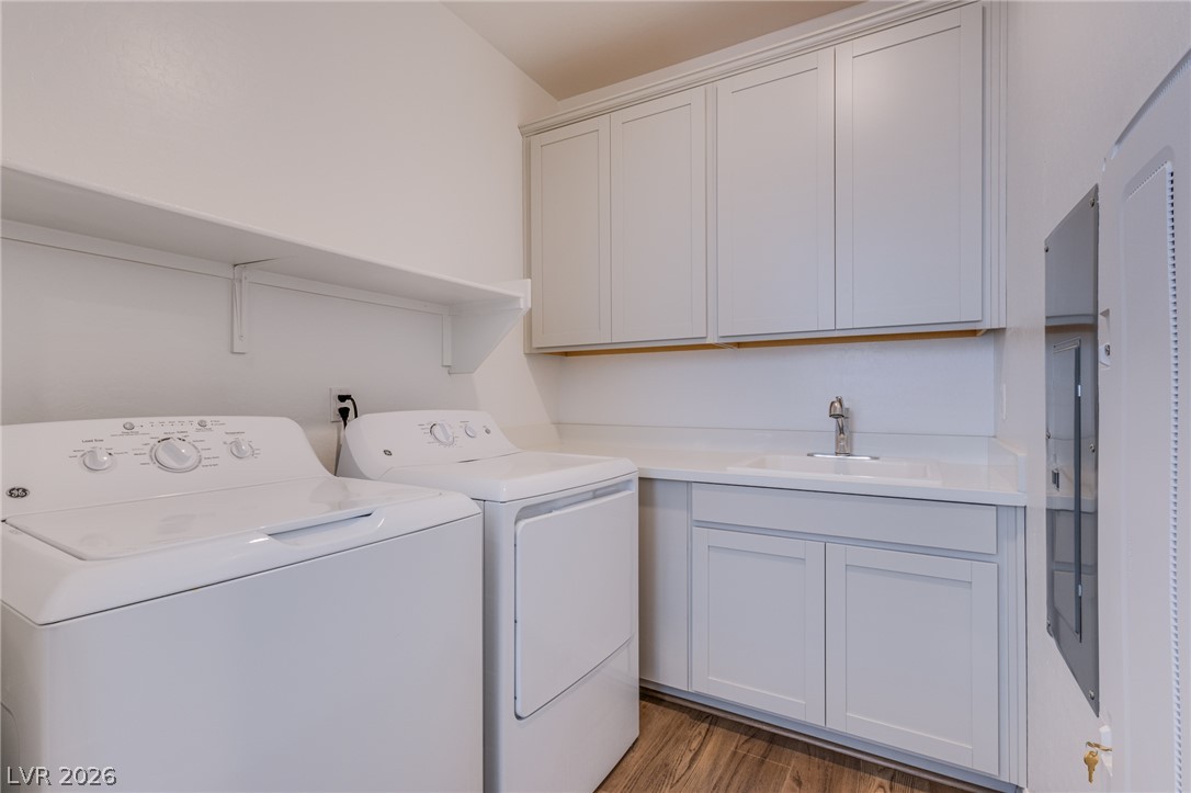 2555 Hampton Road, Unit 8206 Henderson, NV 89052 - Photo 12 of 25 Functional laundry room featuring a utility sink, upper and lower cabinetry, and convenient open shelving.