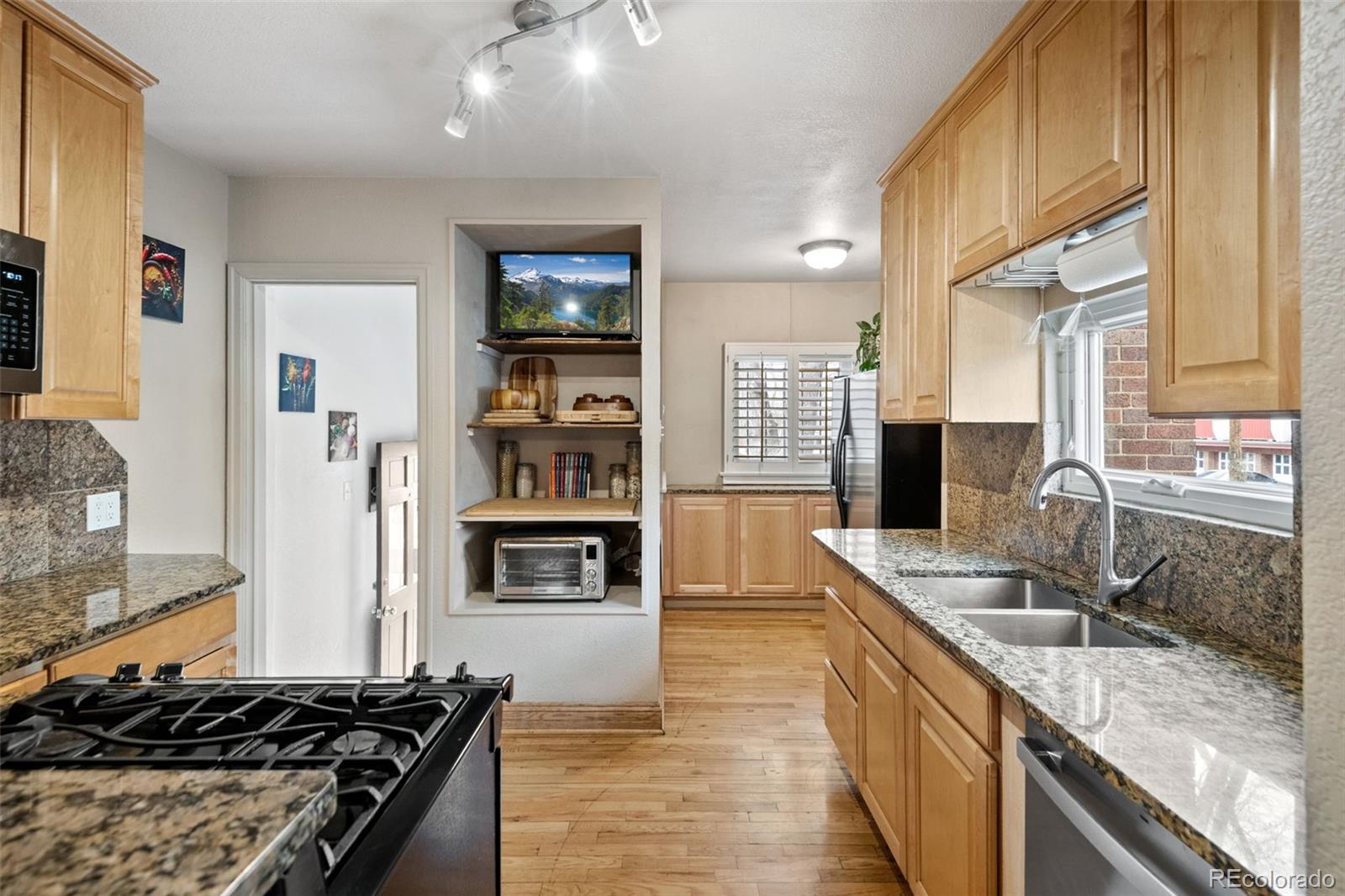 2995 Albion Street Denver, CO 80207 - Photo 14 of 40 a kitchen with stainless steel appliances granite countertop a sink stove and cabinets