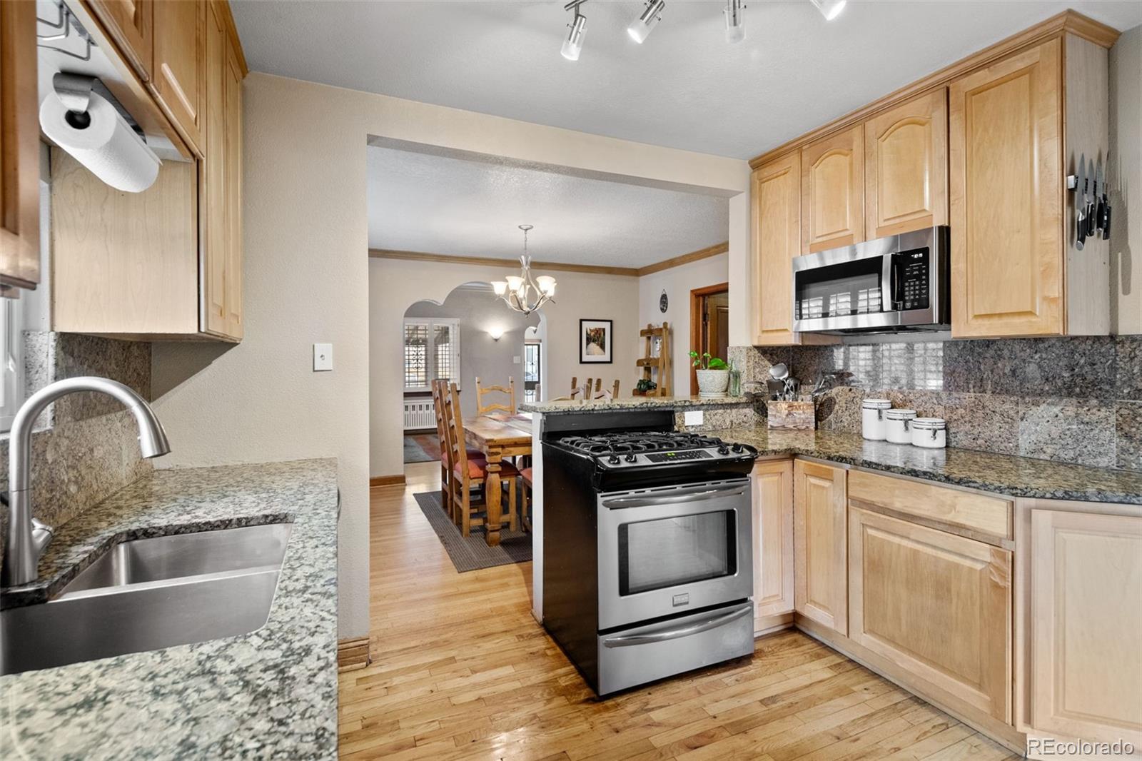 2995 Albion Street Denver, CO 80207 - Photo 15 of 40 a kitchen with stainless steel appliances granite countertop a stove a sink and a microwave