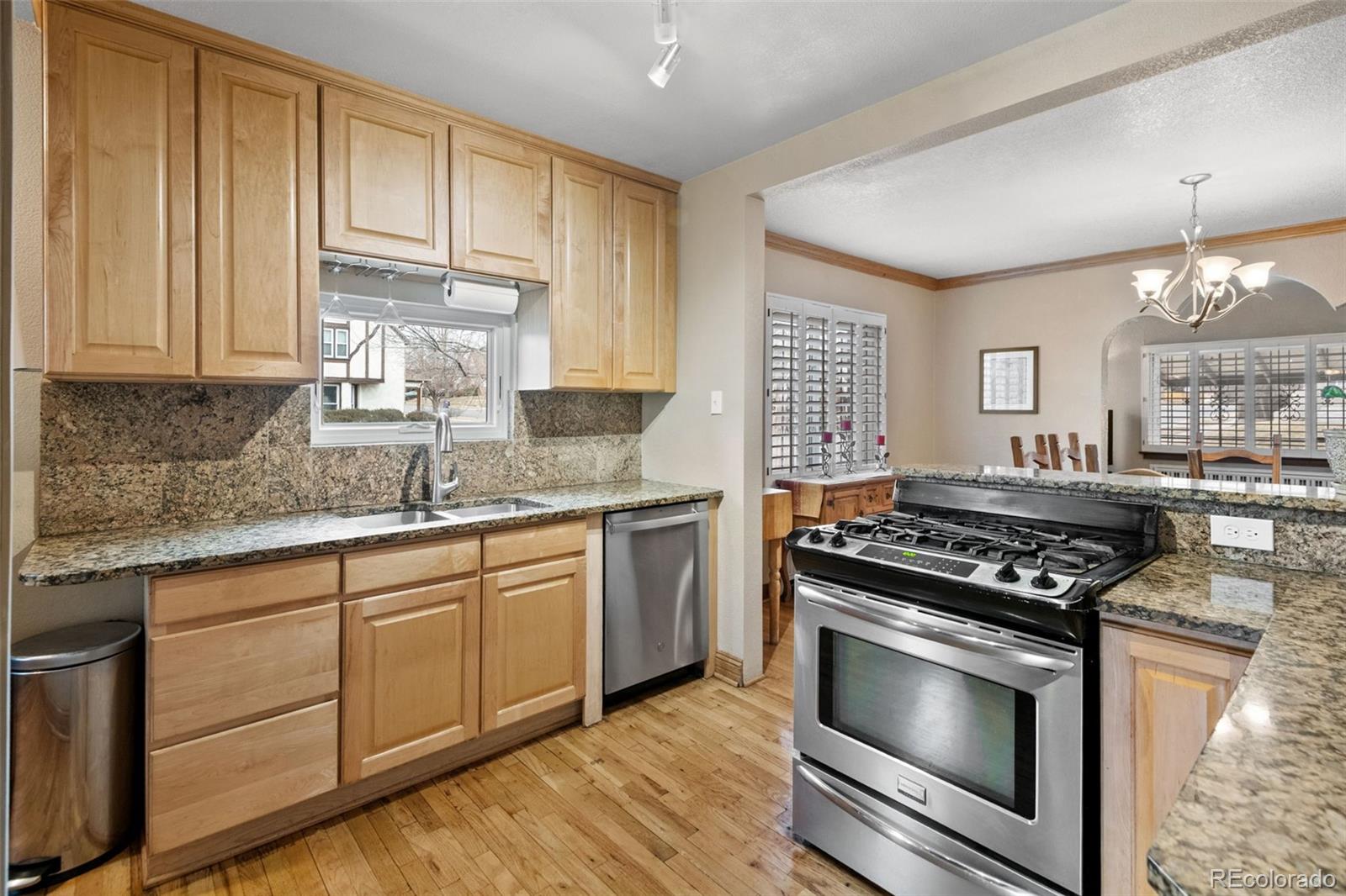 2995 Albion Street Denver, CO 80207 - Photo 16 of 40 a kitchen with granite countertop a stove a sink dishwasher and cabinets with wooden floor