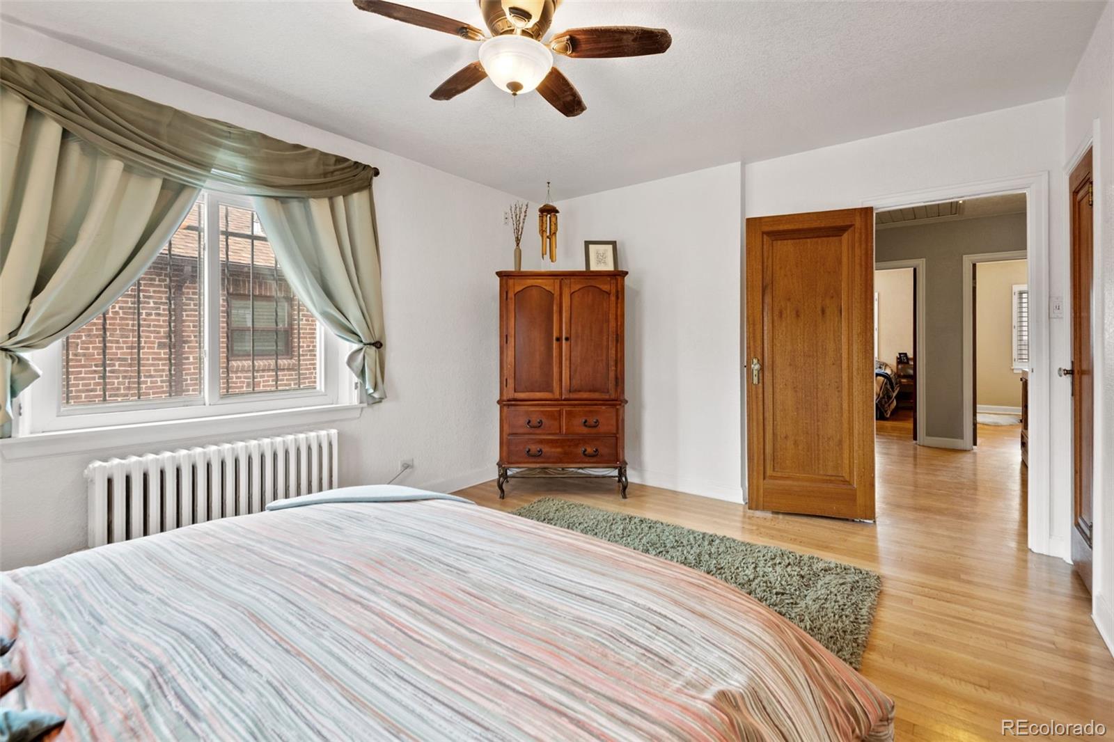 2995 Albion Street Denver, CO 80207 - Photo 19 of 40 a bedroom with a bed and wooden floor