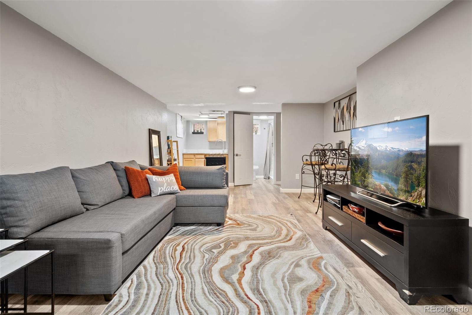 2995 Albion Street Denver, CO 80207 - Photo 22 of 40 a living room with furniture and a flat screen tv