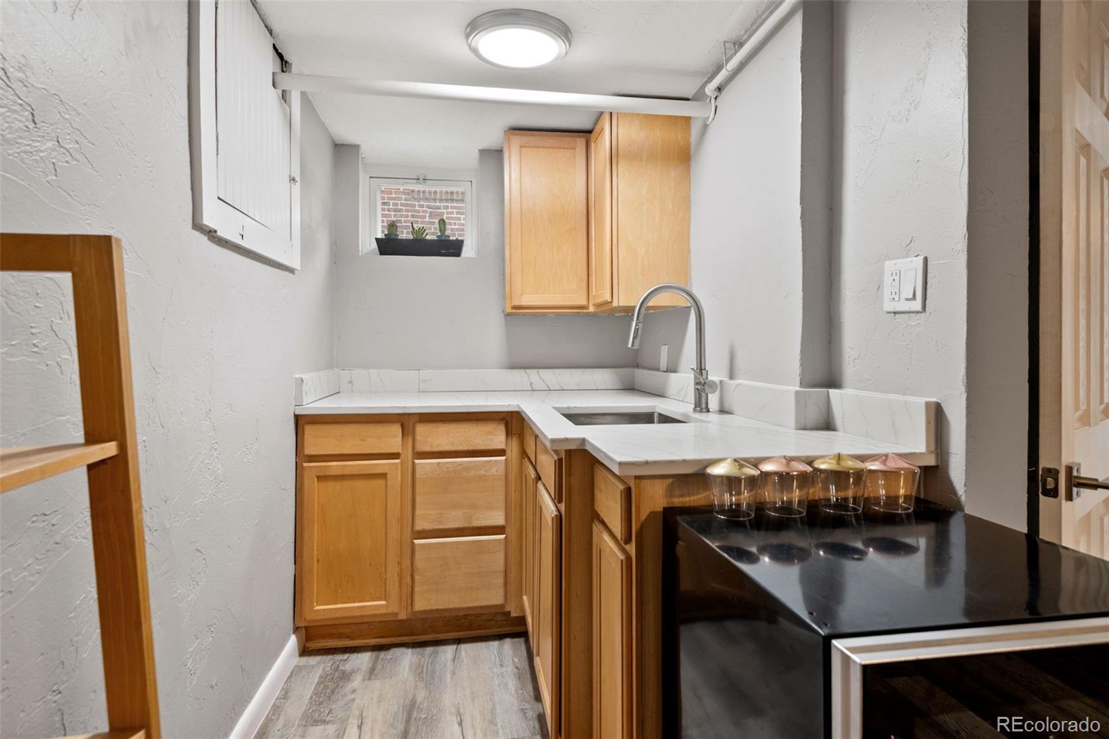 2995 Albion Street Denver, CO 80207 - Photo 25 of 40 a kitchen with a sink stove and cabinets