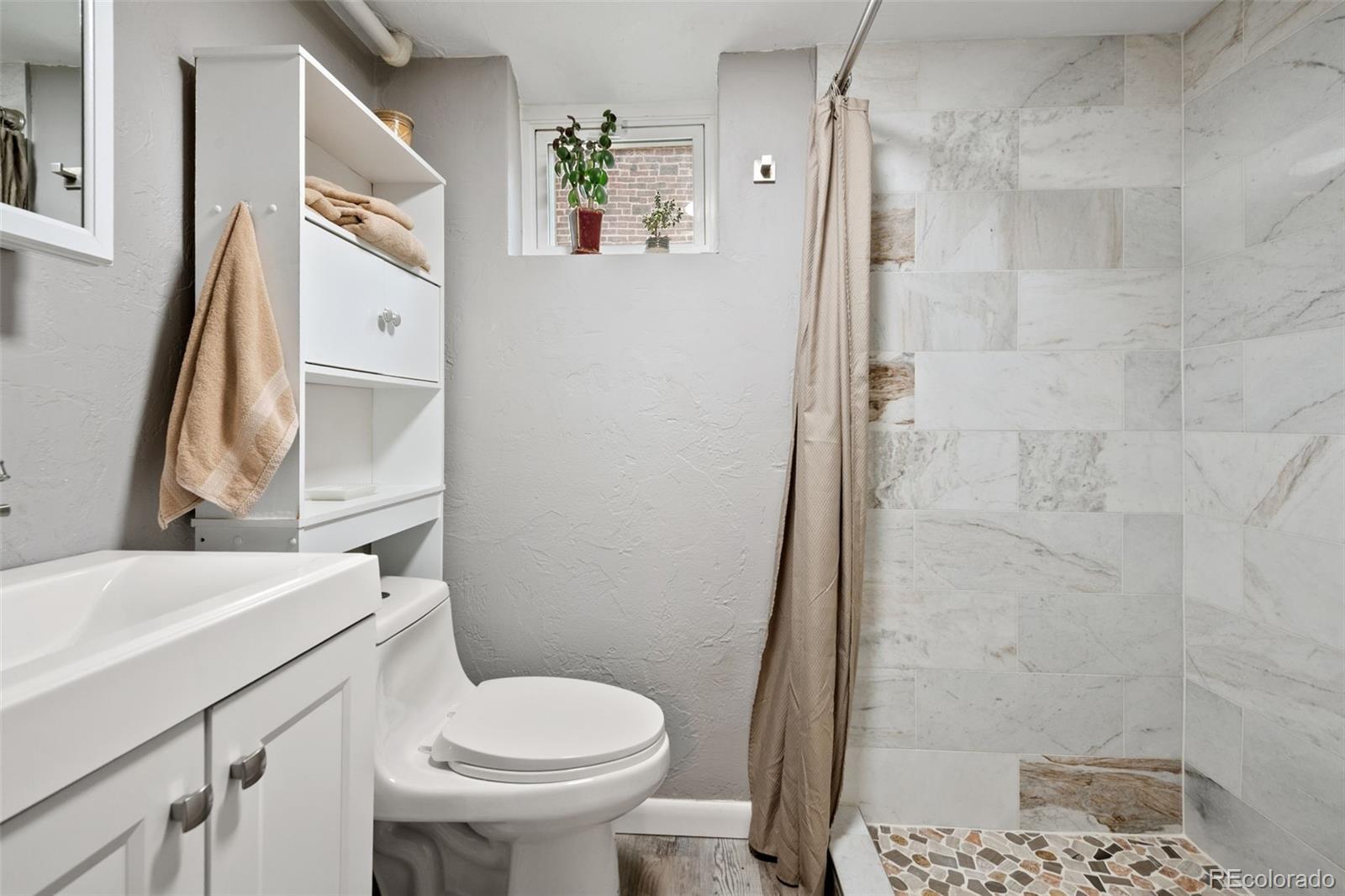 2995 Albion Street Denver, CO 80207 - Photo 26 of 40 a white toilet sitting next to a bathroom sink