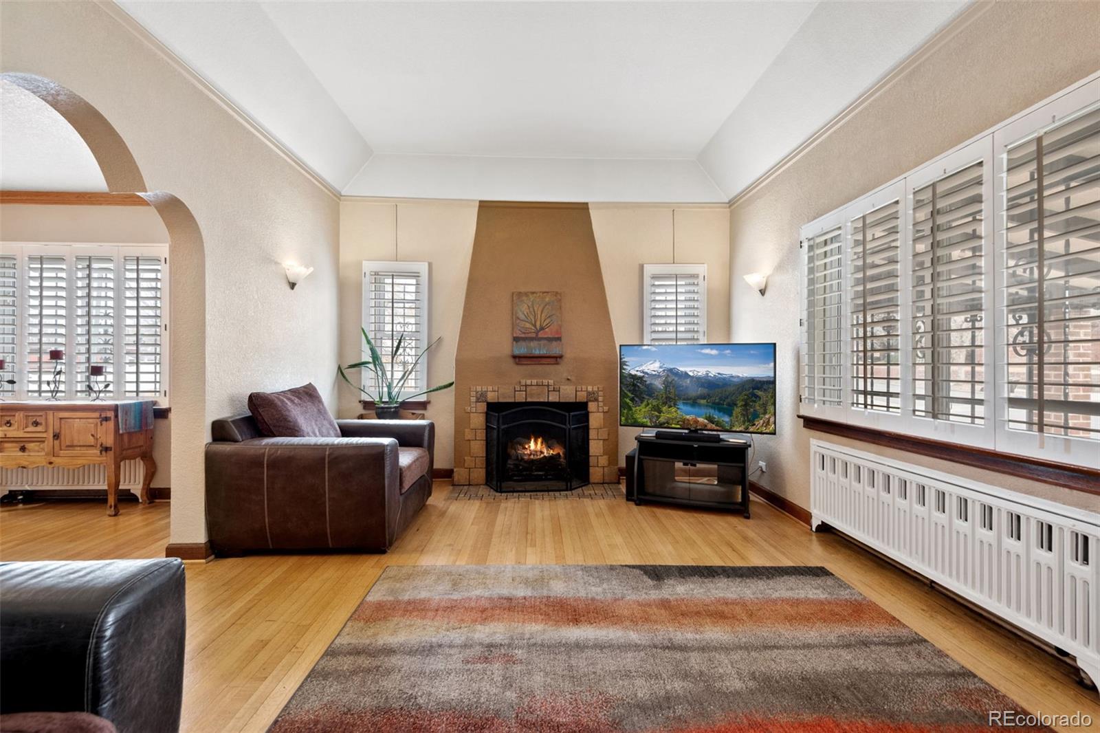 2995 Albion Street Denver, CO 80207 - Photo 5 of 40 a living room with furniture a fireplace and a large window