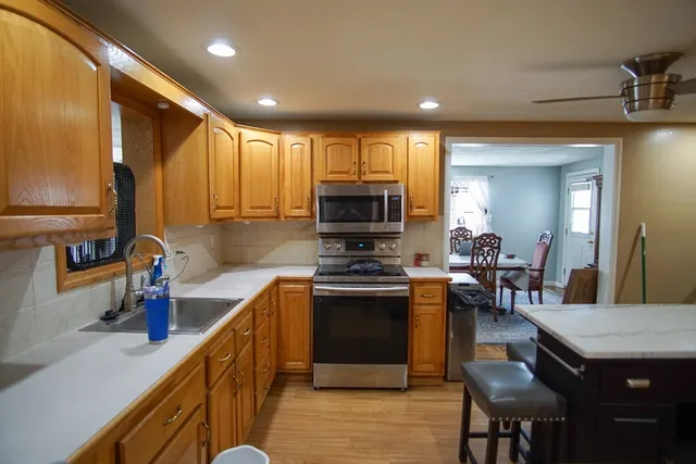 a kitchen with stainless steel appliances granite countertop a stove a sink a refrigerator and a microwave