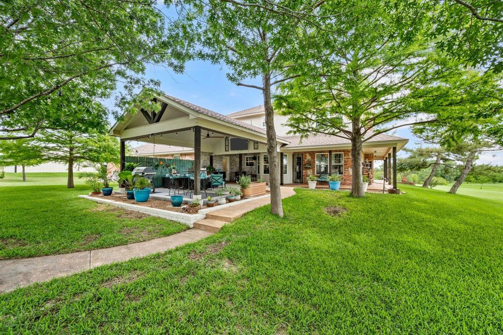 2141 Old Denton Road Decatur, TX 76234 - Photo 30 of 40 Expansive outdoor living area featuring a covered patio with exposed beam vaulted ceiling, a concrete patio, and a dedicated grilling space
