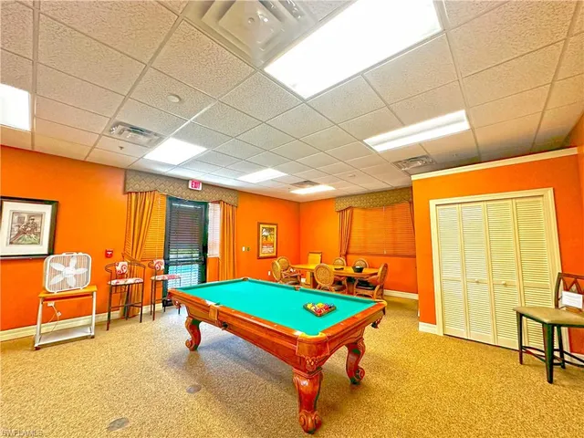 a room with pool tables a rug and a projector