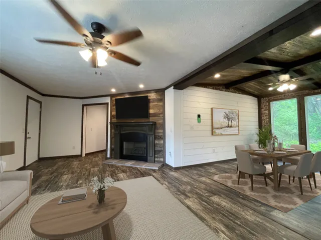 a dining room with furniture a floor to ceiling window and wooden floor