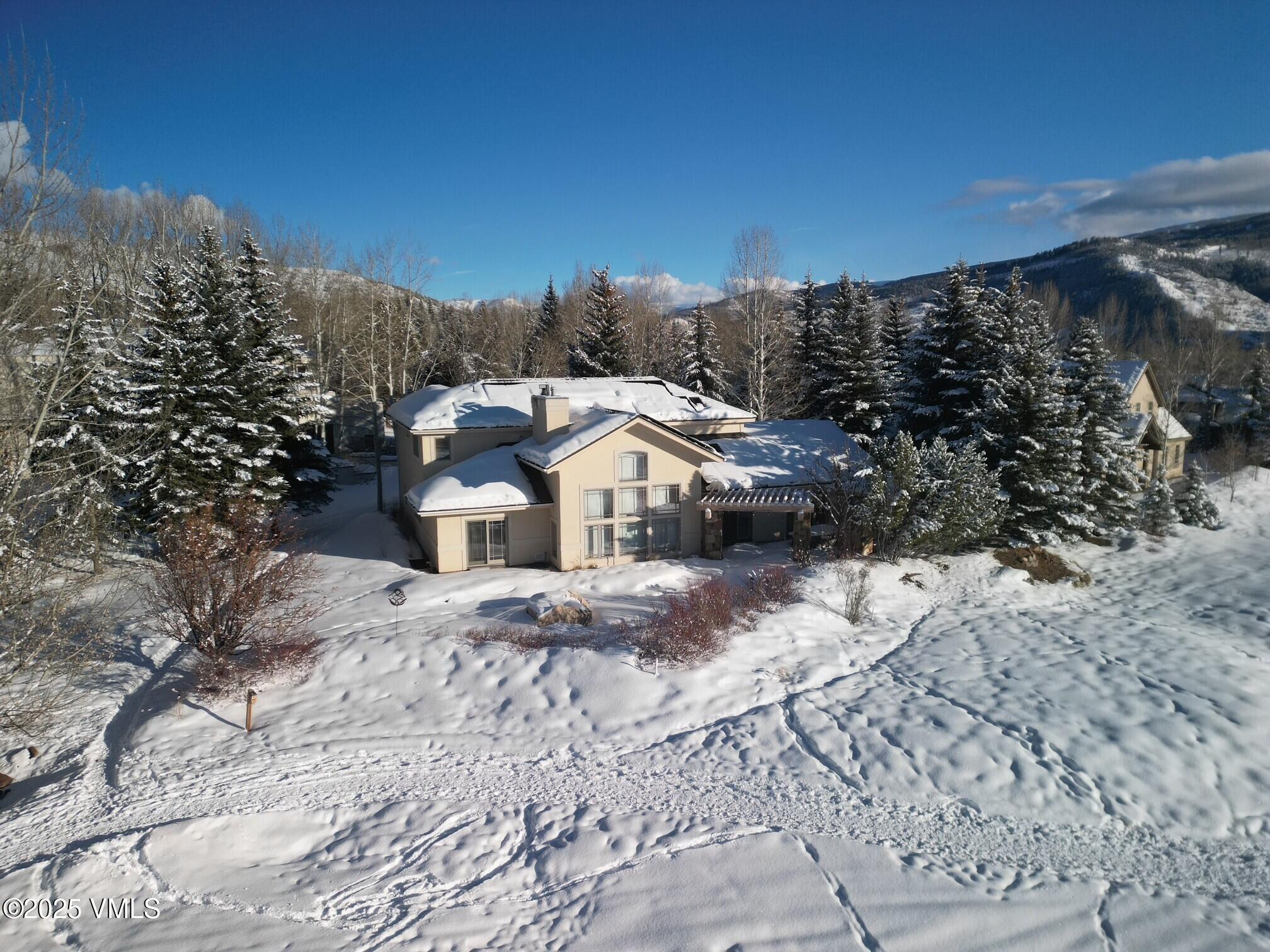 a view of a house with a yard covered with snow in the background