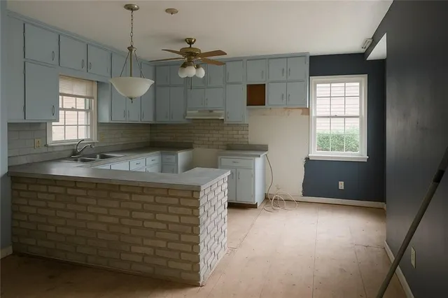 a kitchen with kitchen island a sink stainless steel appliances and window