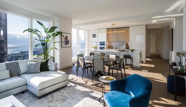 a living room with furniture kitchen view and a potted plant