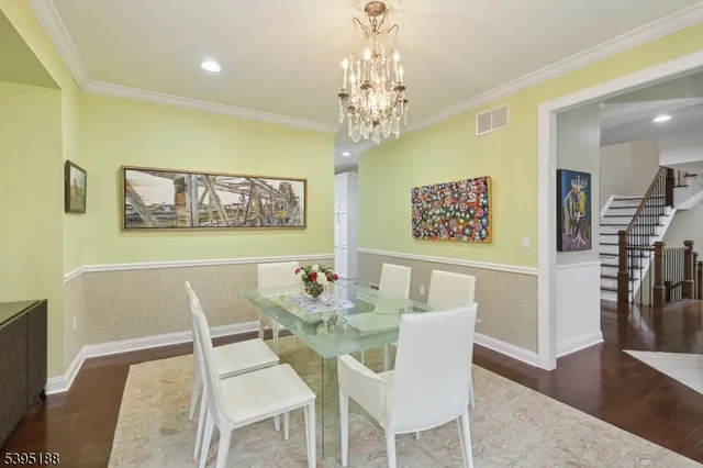 a view of a dining room with furniture a chandelier and wooden floor