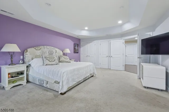 a spacious bedroom with a bed and a flat screen tv