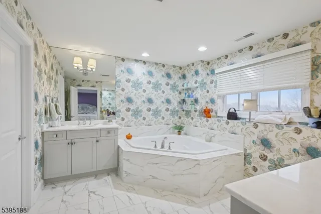 a bathroom with a tub a sink a mirror and shower