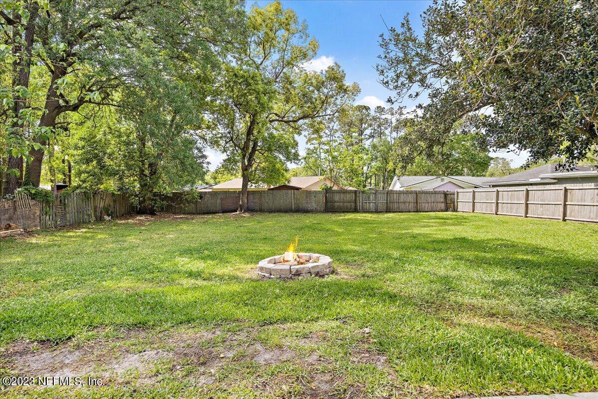 5418 Manfields Place Jacksonville, FL 32207 - Photo 20 of 21 a backyard of a house with table and chairs