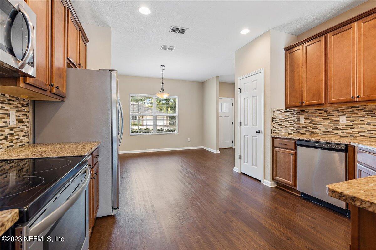 5418 Manfields Place Jacksonville, FL 32207 - Photo 6 of 21 a kitchen with stainless steel appliances granite countertop a stove and a wooden floors