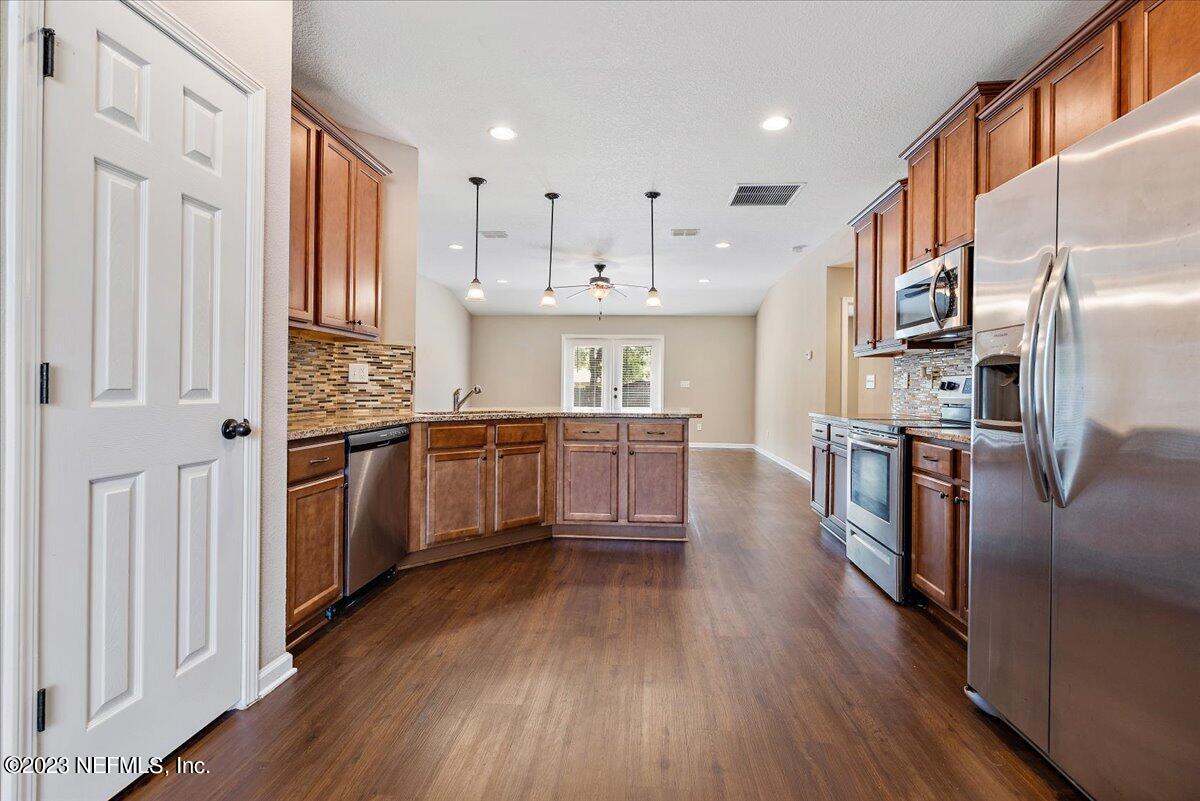 5418 Manfields Place Jacksonville, FL 32207 - Photo 7 of 21 a kitchen with stainless steel appliances granite countertop a refrigerator a stove top oven and cabinets