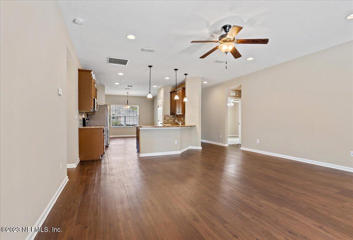 5418 Manfields Place Jacksonville, FL 32207 - Photo 9 of 21 a view of a big room with wooden floor and a kitchen