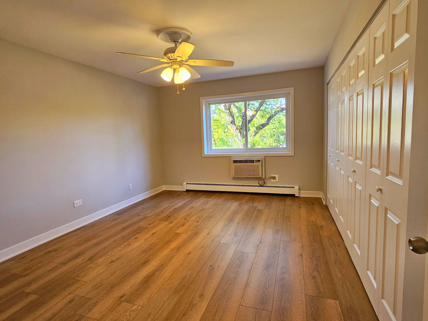 2214 South Goebbert Road, Unit 276 Arlington Heights, IL 60005 - Photo 8 of 17 a view of an empty room with wooden floor and a window
